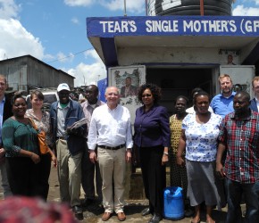 Peter Götz and the Chief Executive Officer of the Water Services Trust Fund, Eng. Jaqueline Musyoki (center), together with representatives of KfW, GIZ and African partners at a water supply kiosk in Mathare Village, Nairobi.
